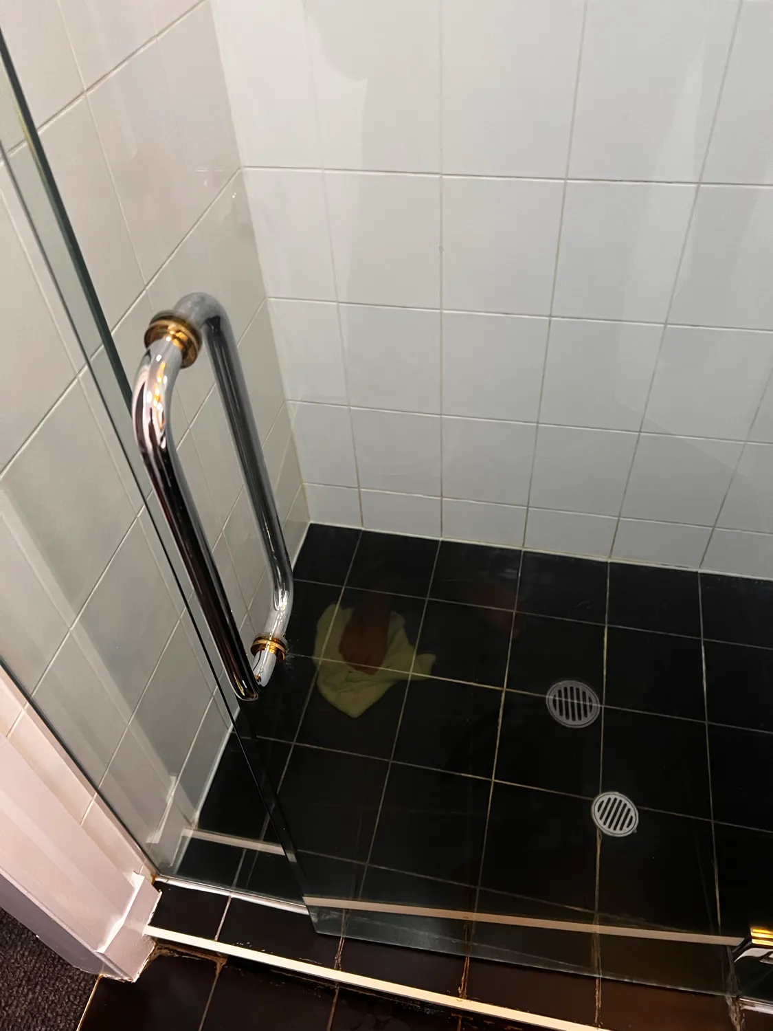 Shower glass with black tiles after cleaning