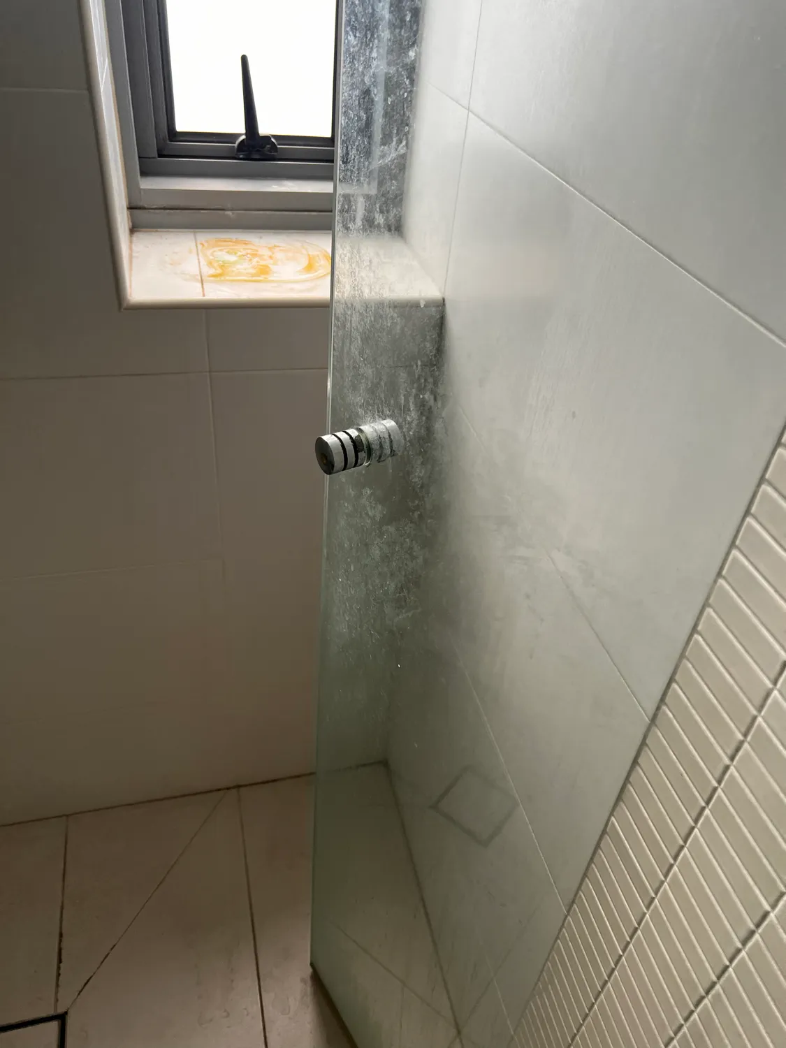 Shower glass with calcium buildup before cleaning