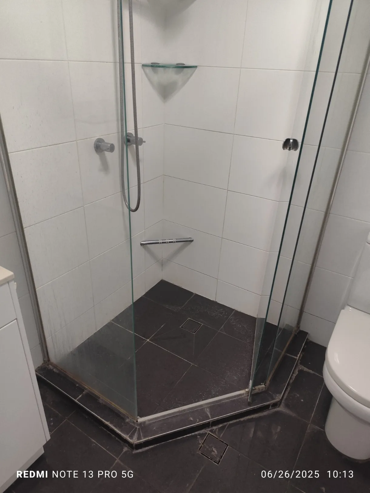 Corner shower screen with grime before cleaning