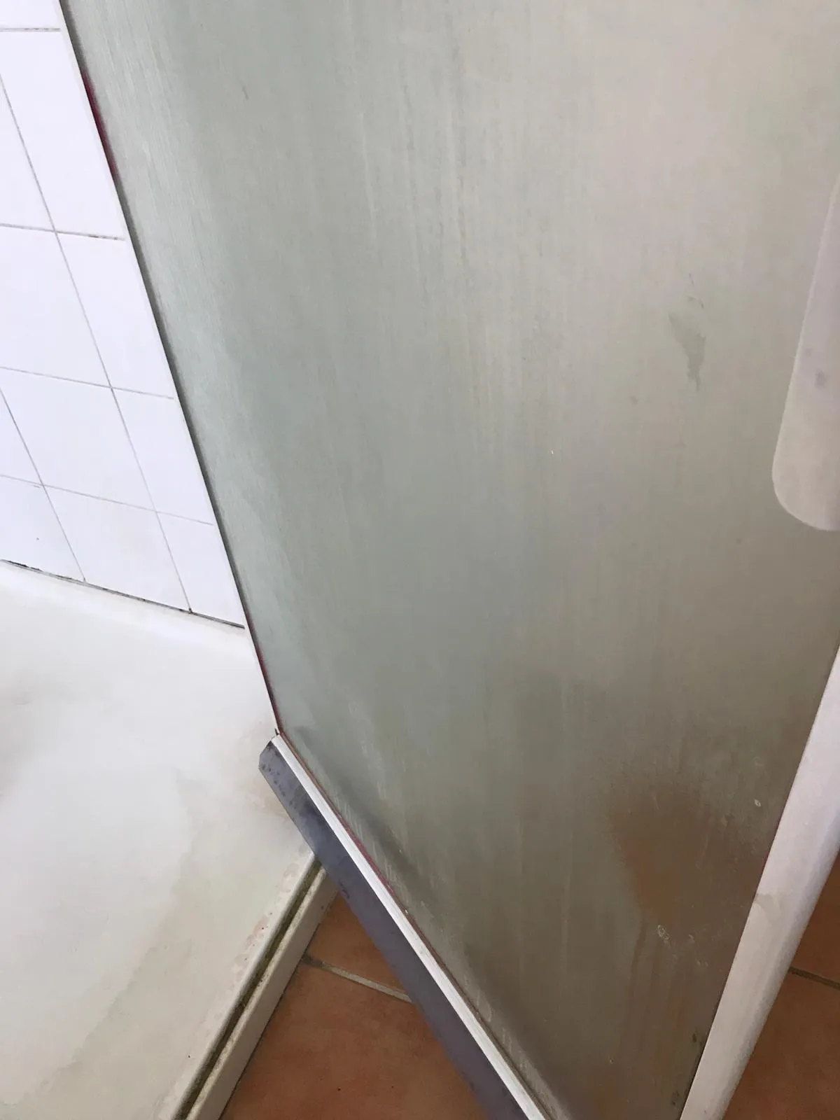 Shower door with bathtub before cleaning