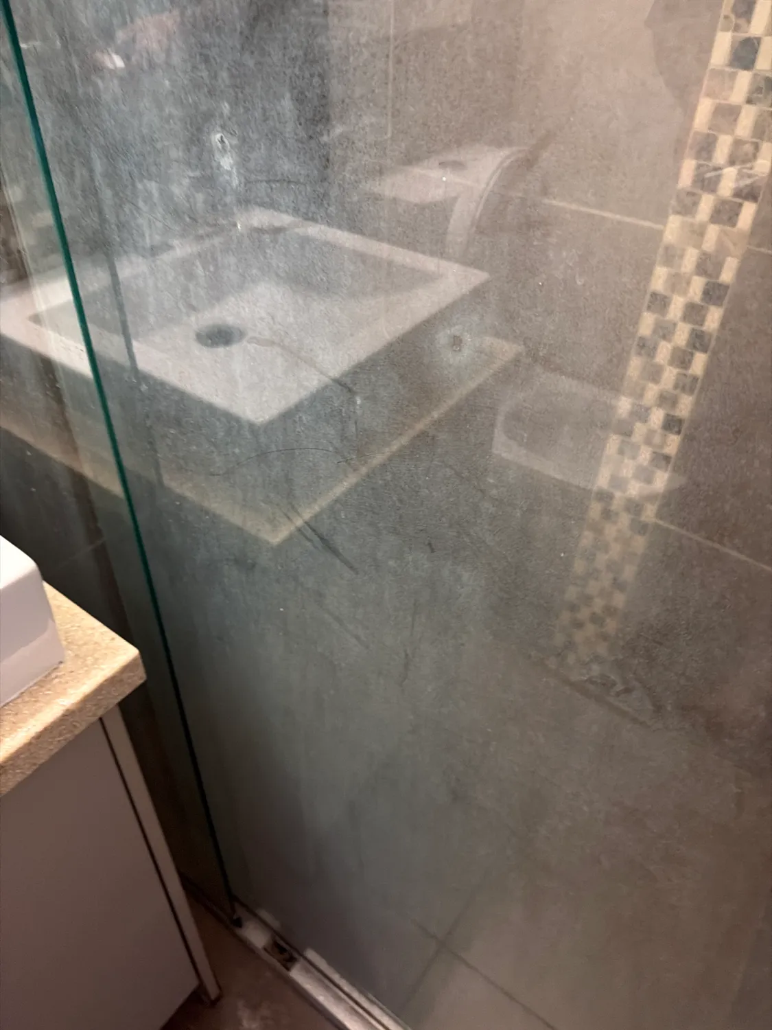 Dirty shower glass reflection before cleaning