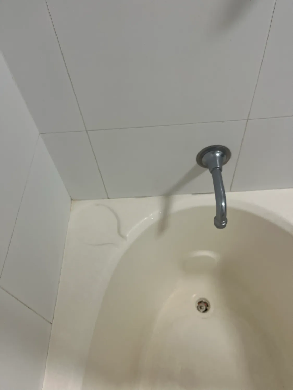Bathtub spout and wall before cleaning
