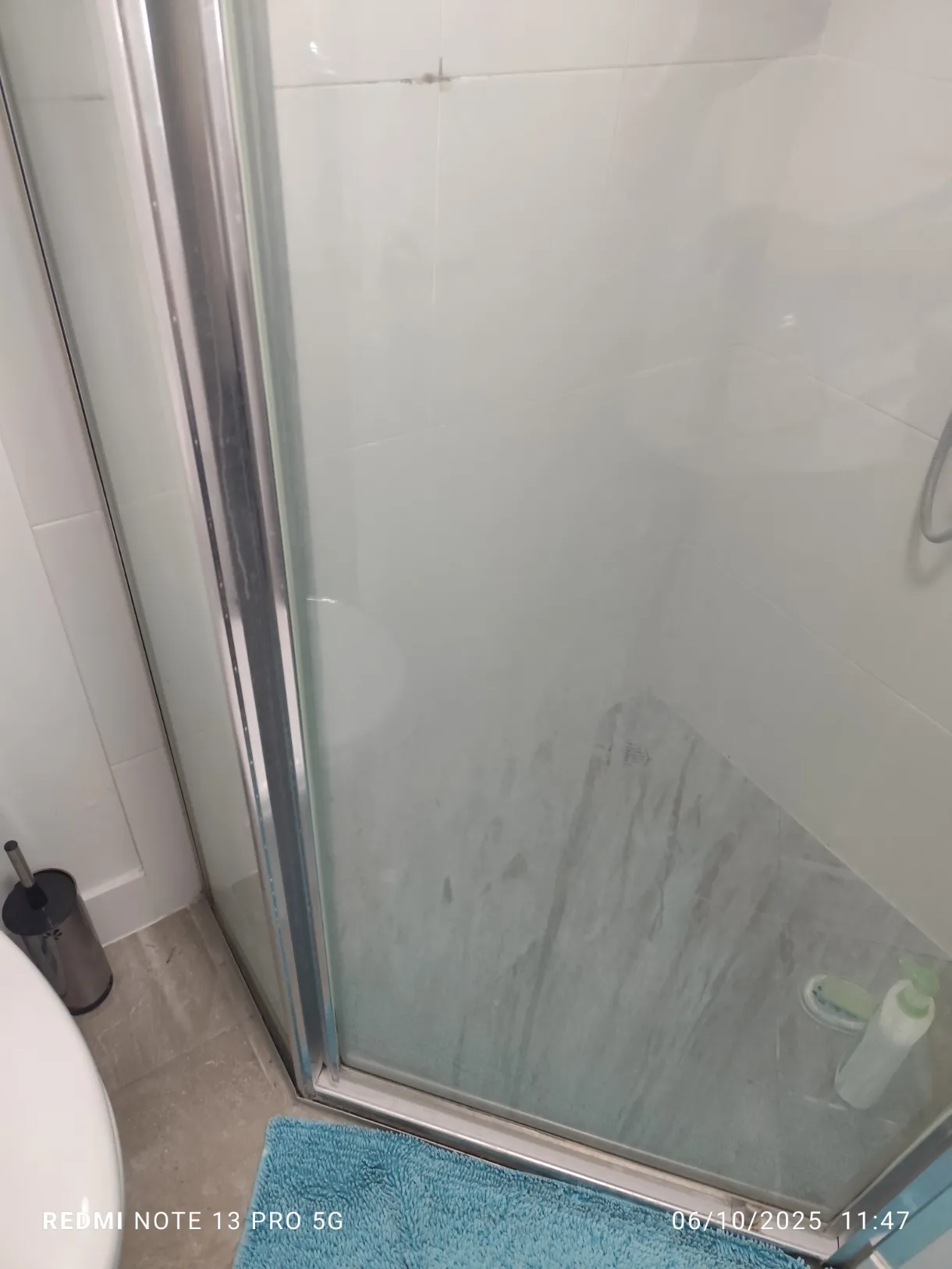 Shower glass with blue mat before cleaning