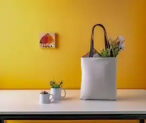 Groceries in a reusable bag, sitting on a bench top