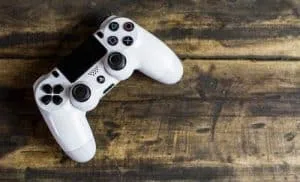 A PS4 (Playstation 4) controller on a wooden bench