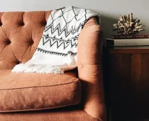 A throw strewn over a brown couch