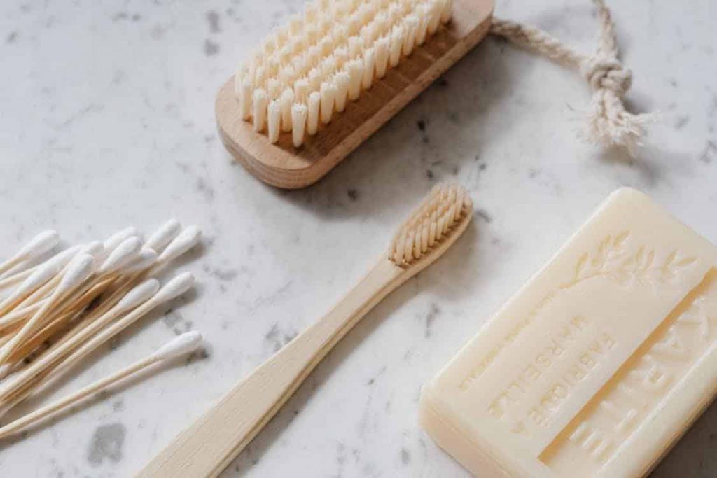 Organic brush, scrub, soap and cotton buds on a marble bench top